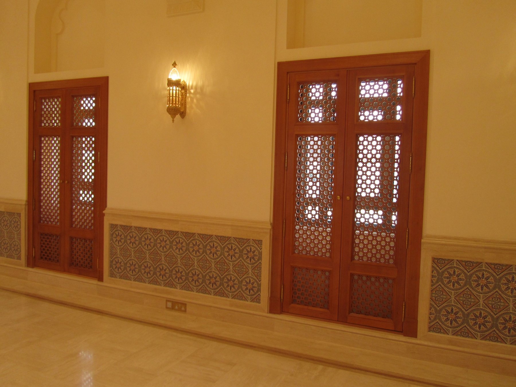 Timber lattice doors above patterned wall tiles in a private interior