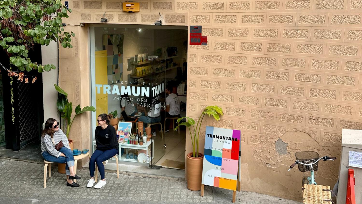 two people sit outside tranmuntana cafe in girona drinking coffee