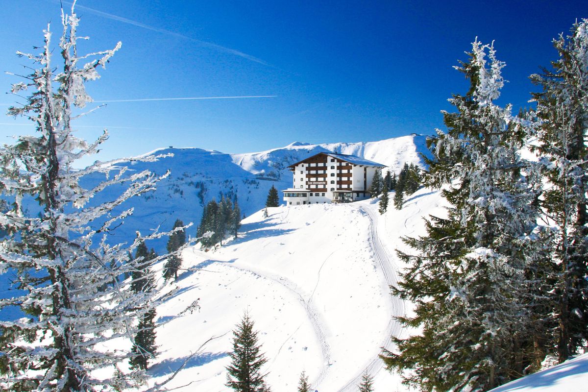 Hotelgebäude in der Ferne auf einem schneebedeckten Berg im Winter