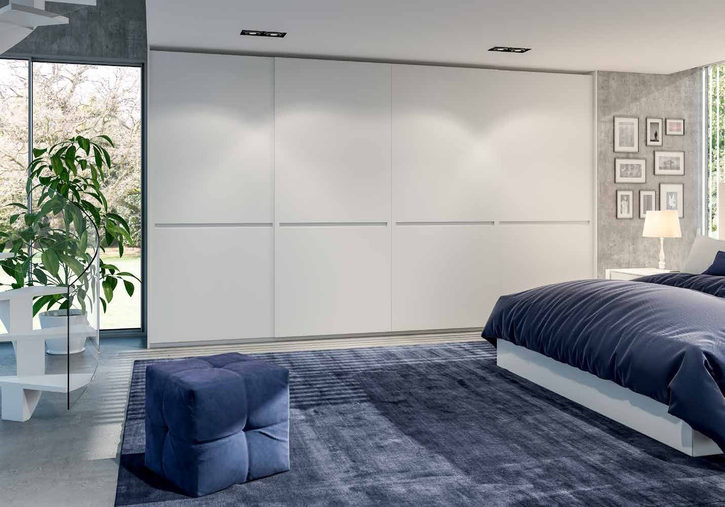 Puertas correderas de armario empotrado en lacado blanco tirador fresado de uñero, en un dormitorio, composición tempro.