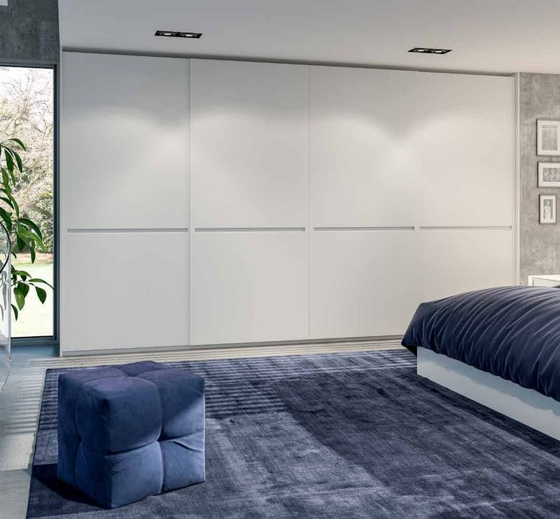 Puertas correderas de armario empotrado en lacado blanco tirador fresado de uñero, en un dormitorio, composición tempro.