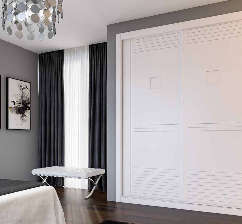 Puertas correderas de armario empotrado en fresado especial y lacado blanco, en un dormitorio, composición slim.