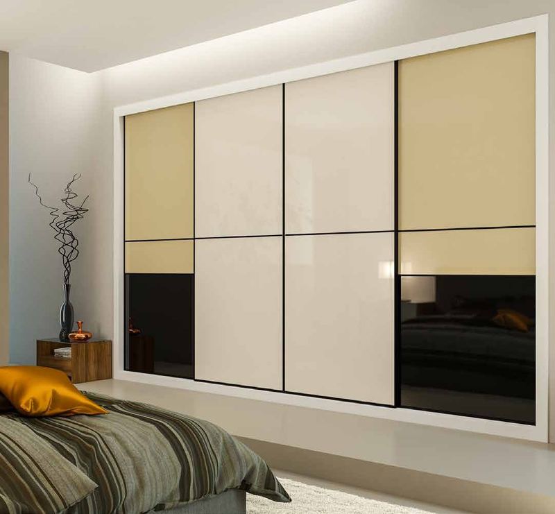Puertas correderas de armario empotrado en vidrio beige, vidrio blanco y vidrio negro, en un dormitorio, composición slim.