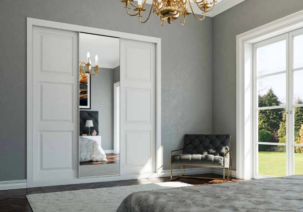 Puertas correderas de armario empotrado en fresado especial y lacado blanco espejo plata, en un dormitorio, composición slim.