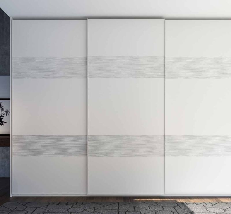 Puertas correderas de armario empotrado en tablero de una única pieza fresado especial y lacado blanco, en un dormitorio, composición tempro.