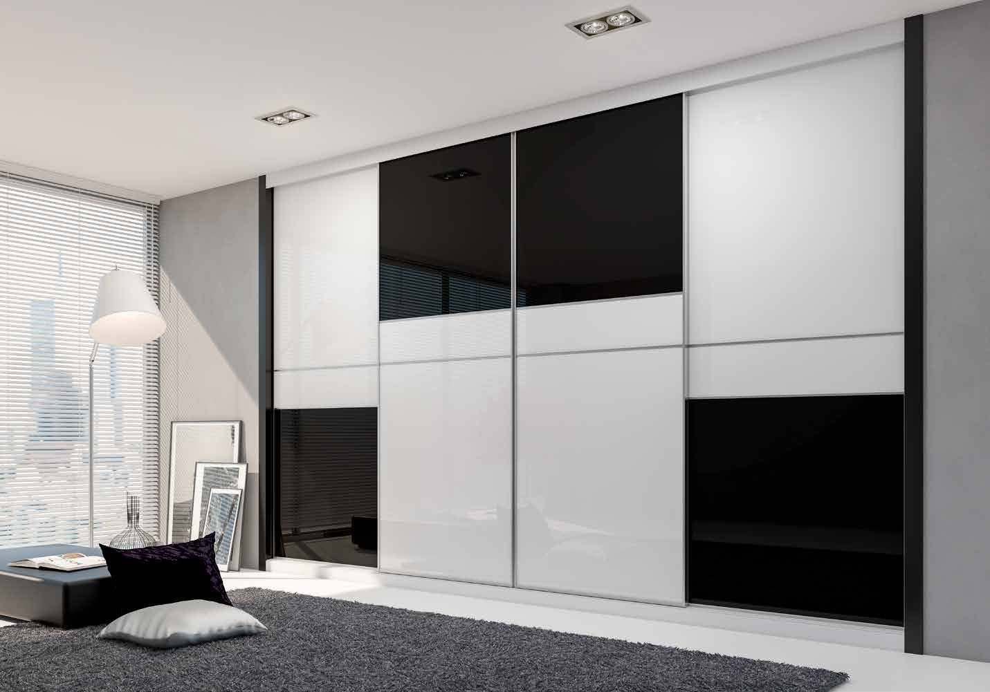 Puertas correderas de armario empotrado en vidrio blanco y vidrio negro, en un dormitorio, composición slim.