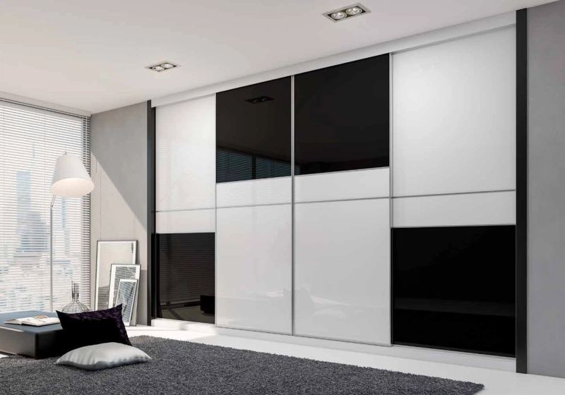 Puertas correderas de armario empotrado en vidrio blanco y vidrio negro, en un dormitorio, composición slim.