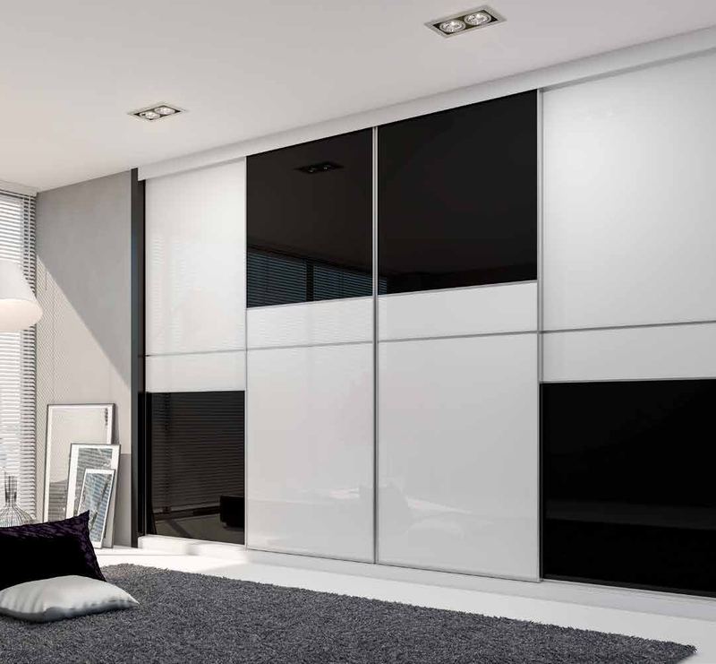 Puertas correderas de armario empotrado en vidrio blanco y vidrio negro, en un dormitorio, composición slim.