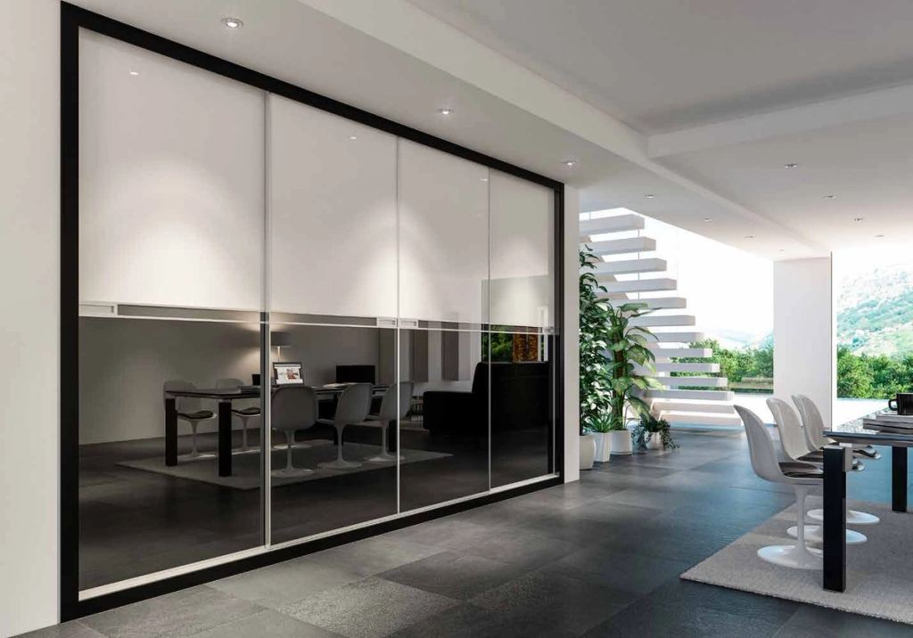 Puertas correderas de armario empotrado en vidrio blanco y vidrio negro, en un dormitorio, composición slim.