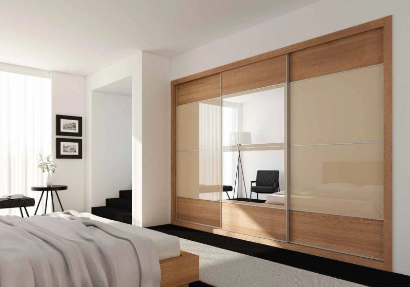 Puertas correderas de armario empotrado en nogal pacífico, vidrio beige y espejo, en un dormitorio, composición slim.