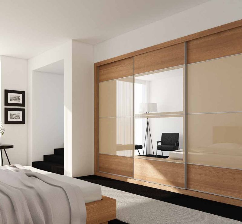 Puertas correderas de armario empotrado en nogal pacífico, vidrio beige y espejo, en un dormitorio, composición slim.