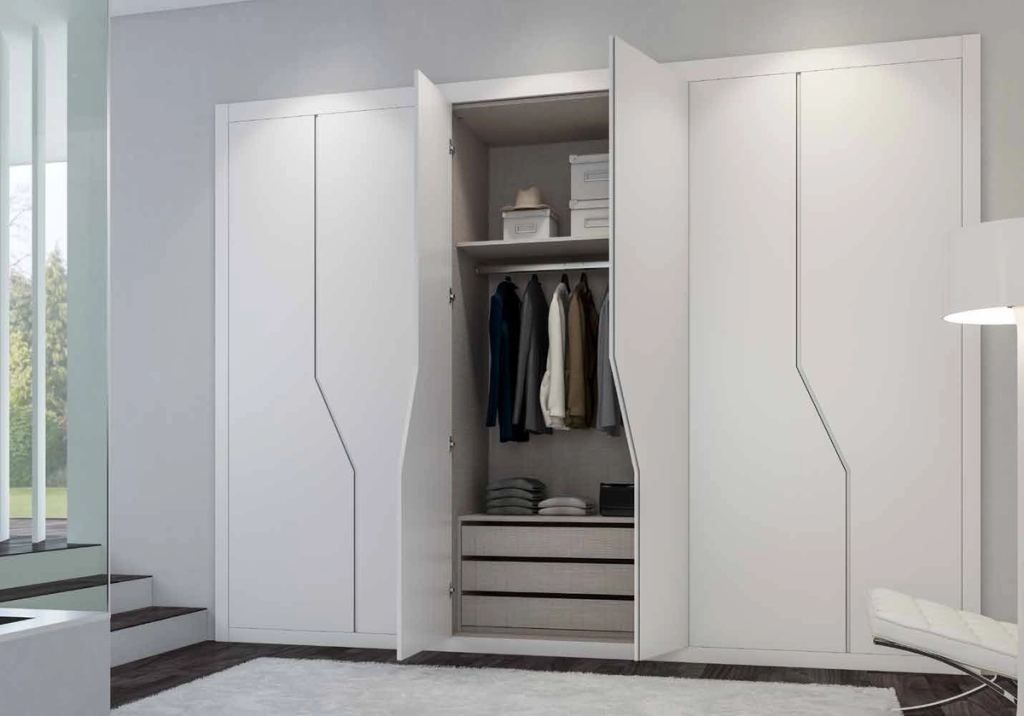 Puertas correderas de armario empotrado en lacado blanco tirador fresado de uñero, en un dormitorio.