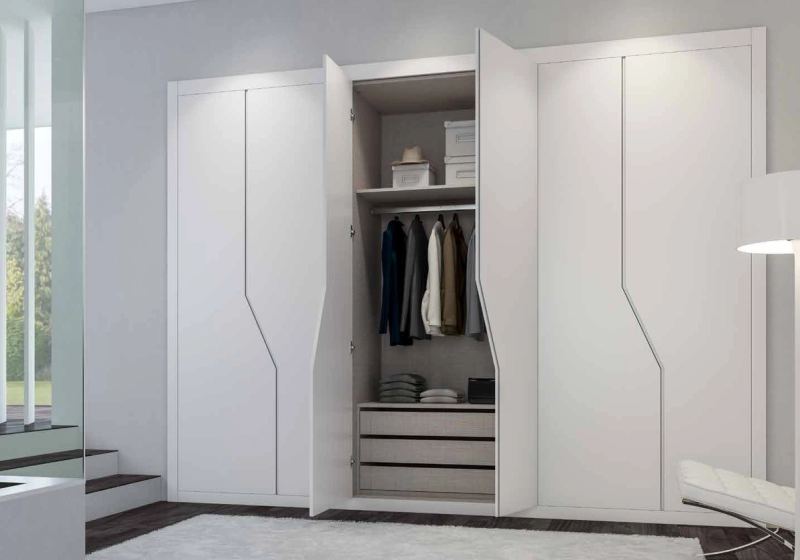 Puertas correderas de armario empotrado en lacado blanco tirador fresado de uñero, en un dormitorio.