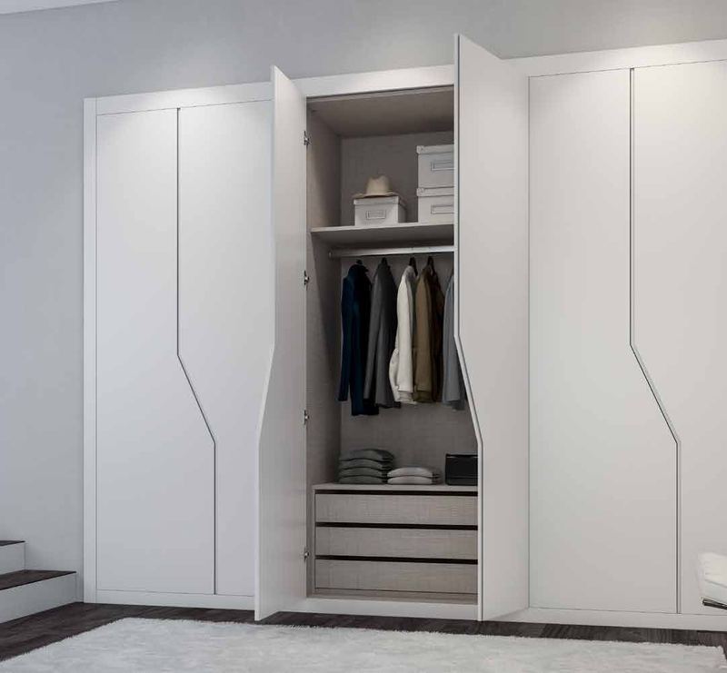 Puertas correderas de armario empotrado en lacado blanco tirador fresado de uñero, en un dormitorio.