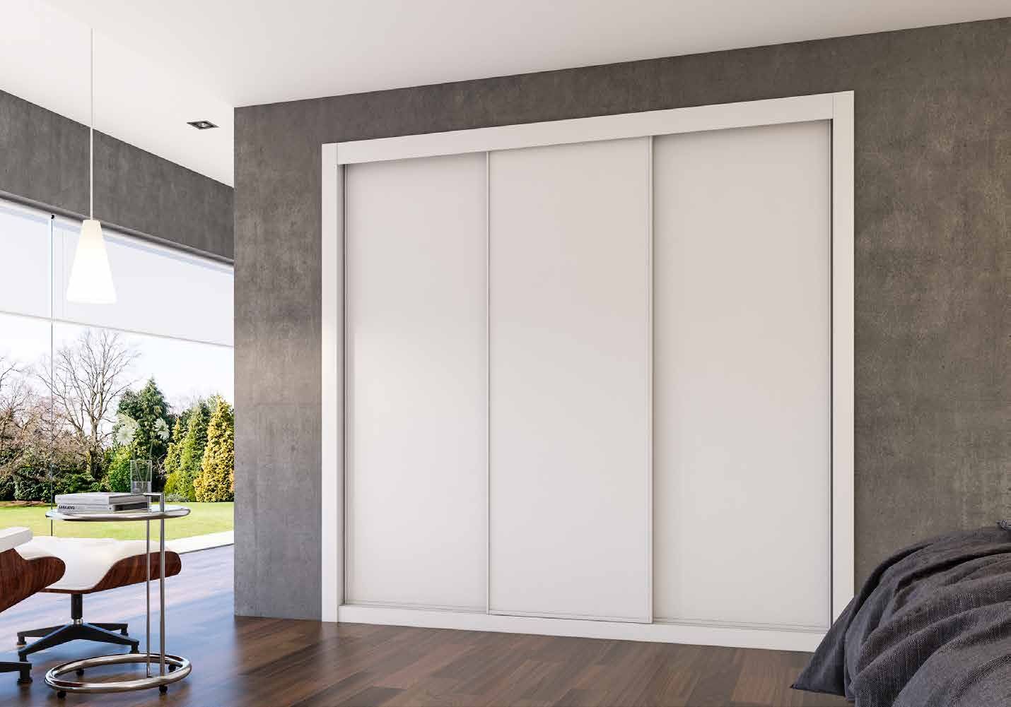 Puertas correderas de armario empotrado en blanco, en un dormitorio, composición slim.