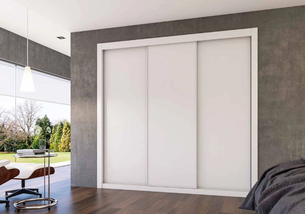 Puertas correderas de armario empotrado en blanco, en un dormitorio, composición slim.