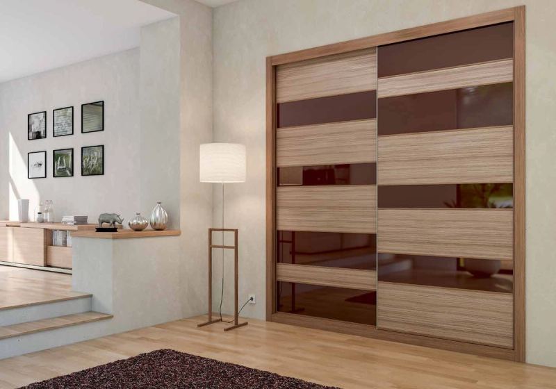 Puertas correderas de armario empotrado en coco-bolo y vidrio chocolate, en un dormitorio, composición slim.