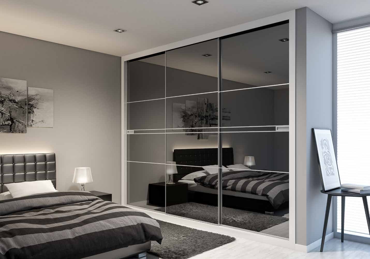 Puertas correderas de armario empotrado en vidrio negro, en un dormitorio, composición slim.