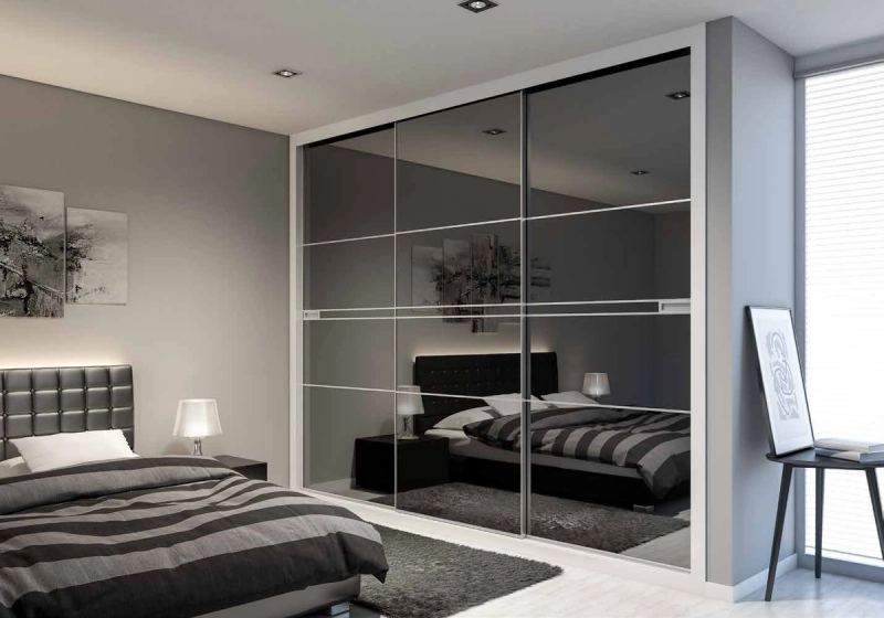 Puertas correderas de armario empotrado en vidrio negro, en un dormitorio, composición slim.