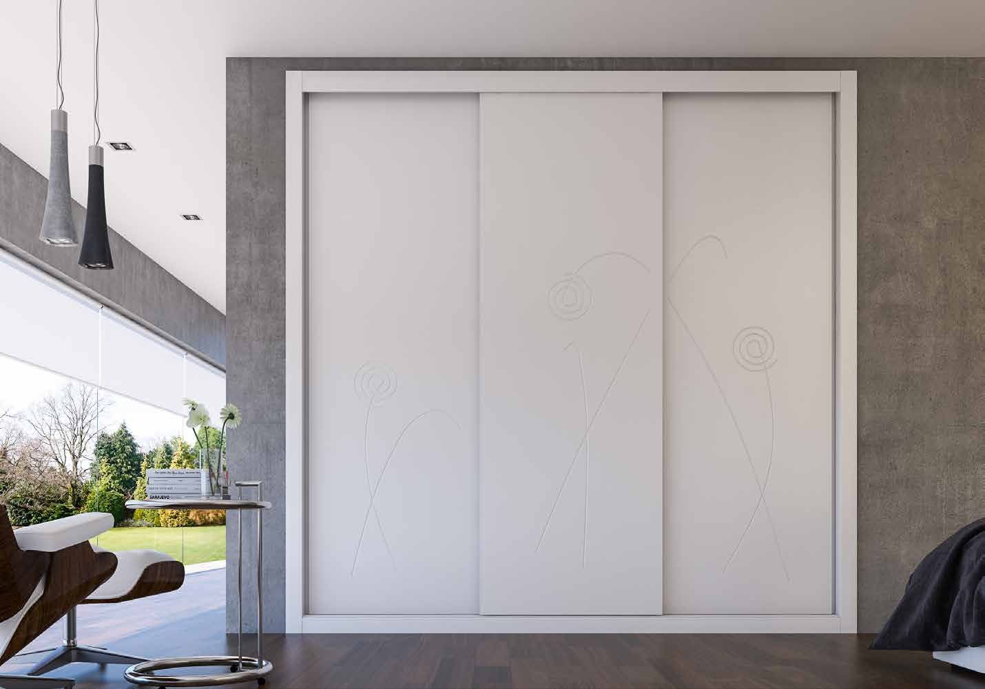Puertas correderas de armario empotrado en fresado flor y lacado blanco, en un dormitorio, composición lite.