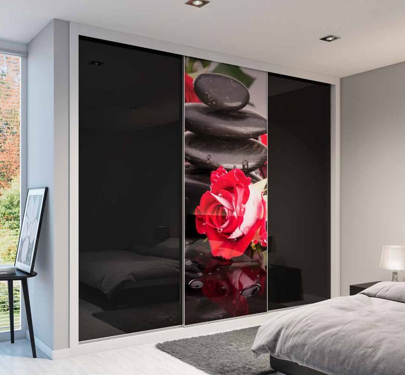 Puertas correderas de armario empotrado en vidrio negro, en un dormitorio, composición slim.