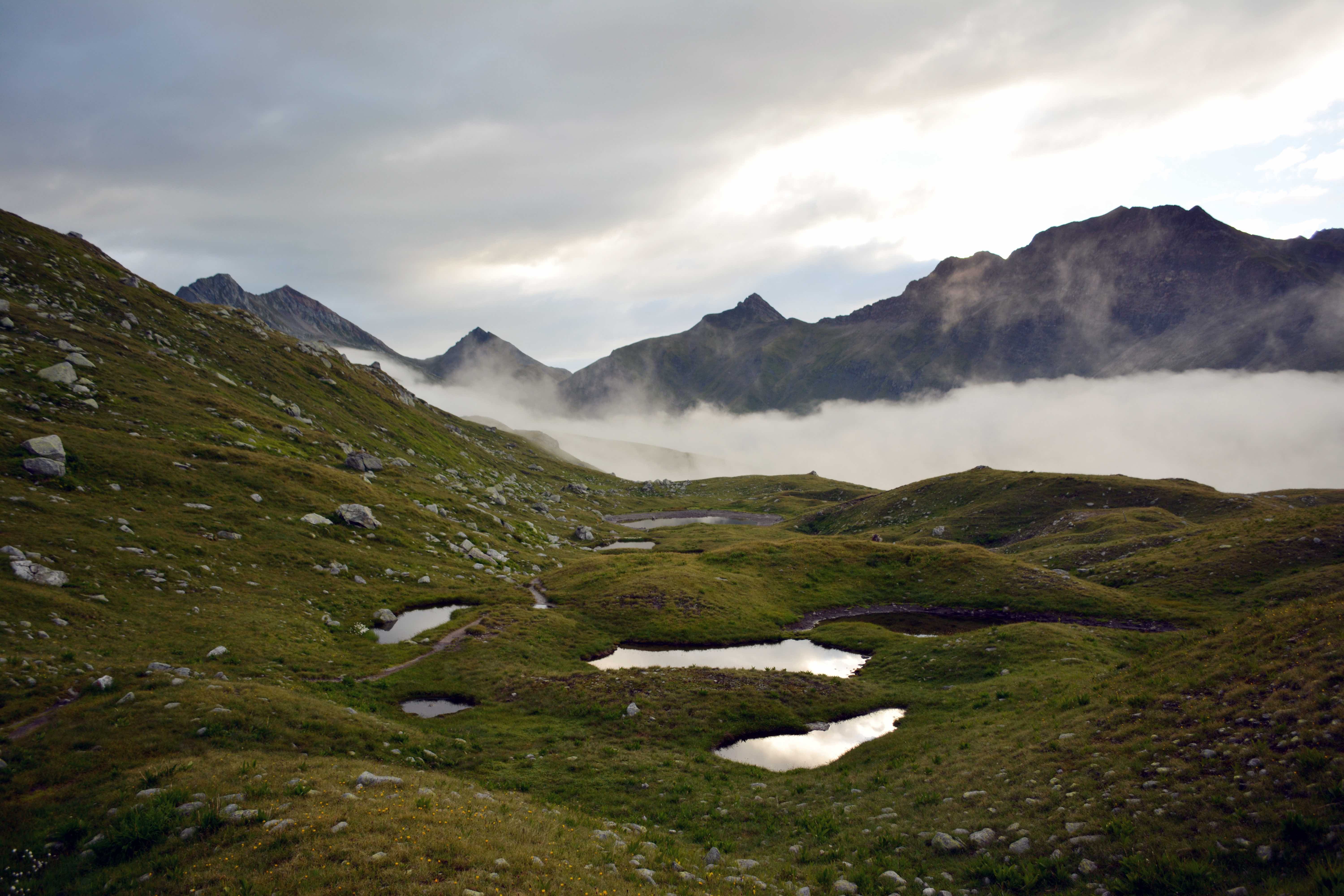 Plan la Greina mit Bodennebel, im Hintergrund die Bergkette vom Piz Zaum