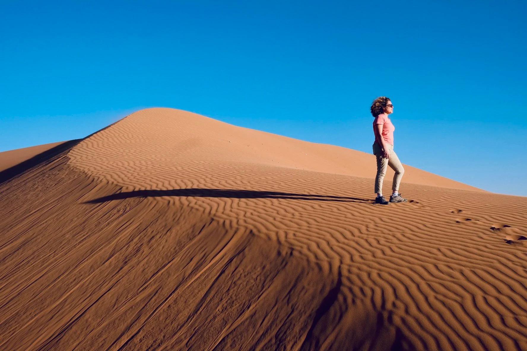 Nathalie Debeir sur une dune de sable qui contemple le champ des possibles