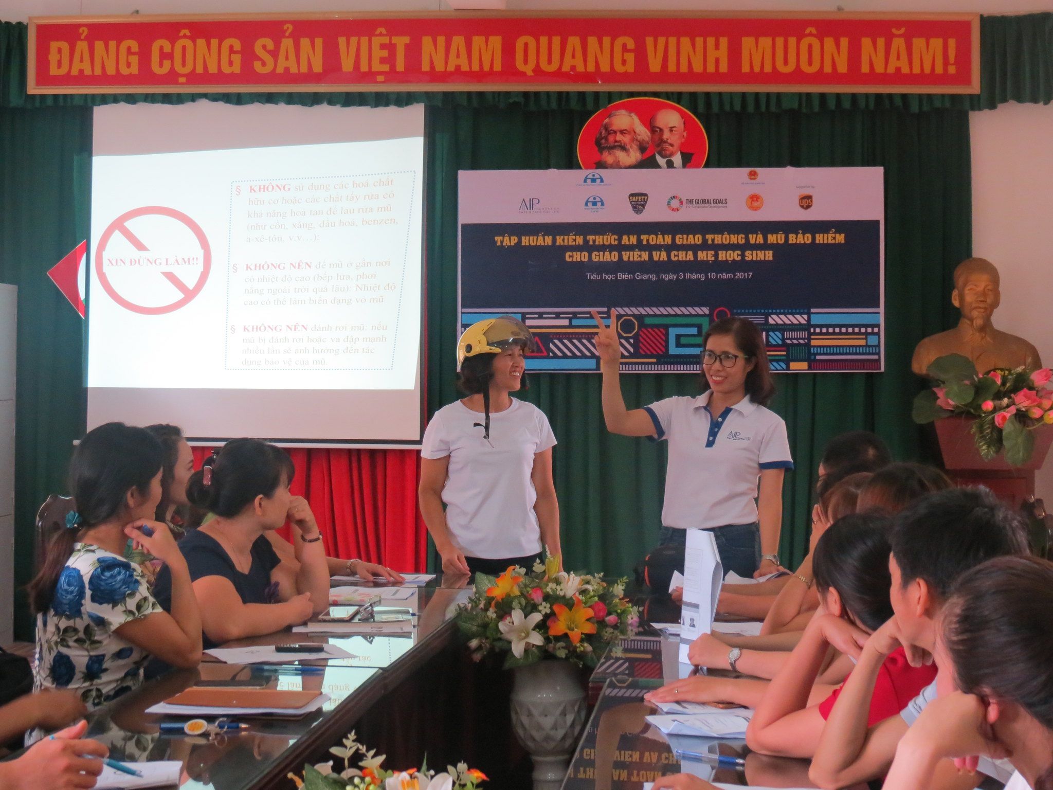 AIP Foundation staff demonstrate the proper helmet wearing technique during the training workshop.