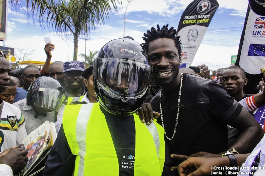 Bobi Wine gives a motorcyclist an autographed reflective vest for following proper road safety