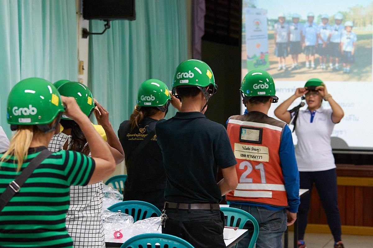 Parents receive instructions for wearing helmets correctly at a training workshop at Wat Chong Nonsi School.