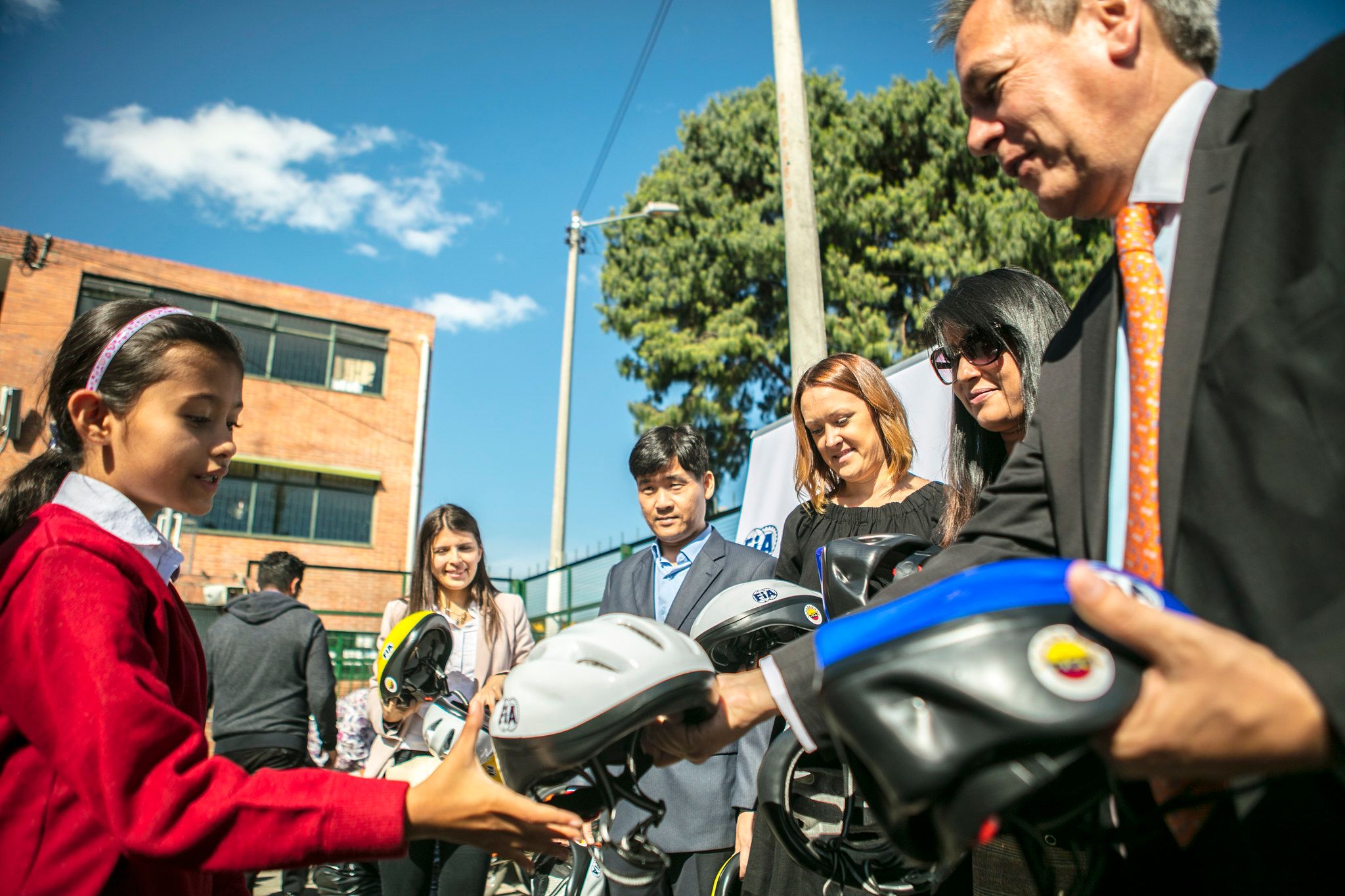 (From left) A student receives a helmet from Paola Moya, Quality Assurance Coordinator, Touring & Automóvil Club de Colombia; Pagna Kim, Cambodia Country Director, AIP Foundation; Roxy Gleeson, M&E Advisor, AIP Foundation; Monalisa Adhikari, Programmes Coordinator, FIA Foundation; and Alfredo Albornoz Guerrero, Director General, Touring & Automóvil Club de Colombia during the training.