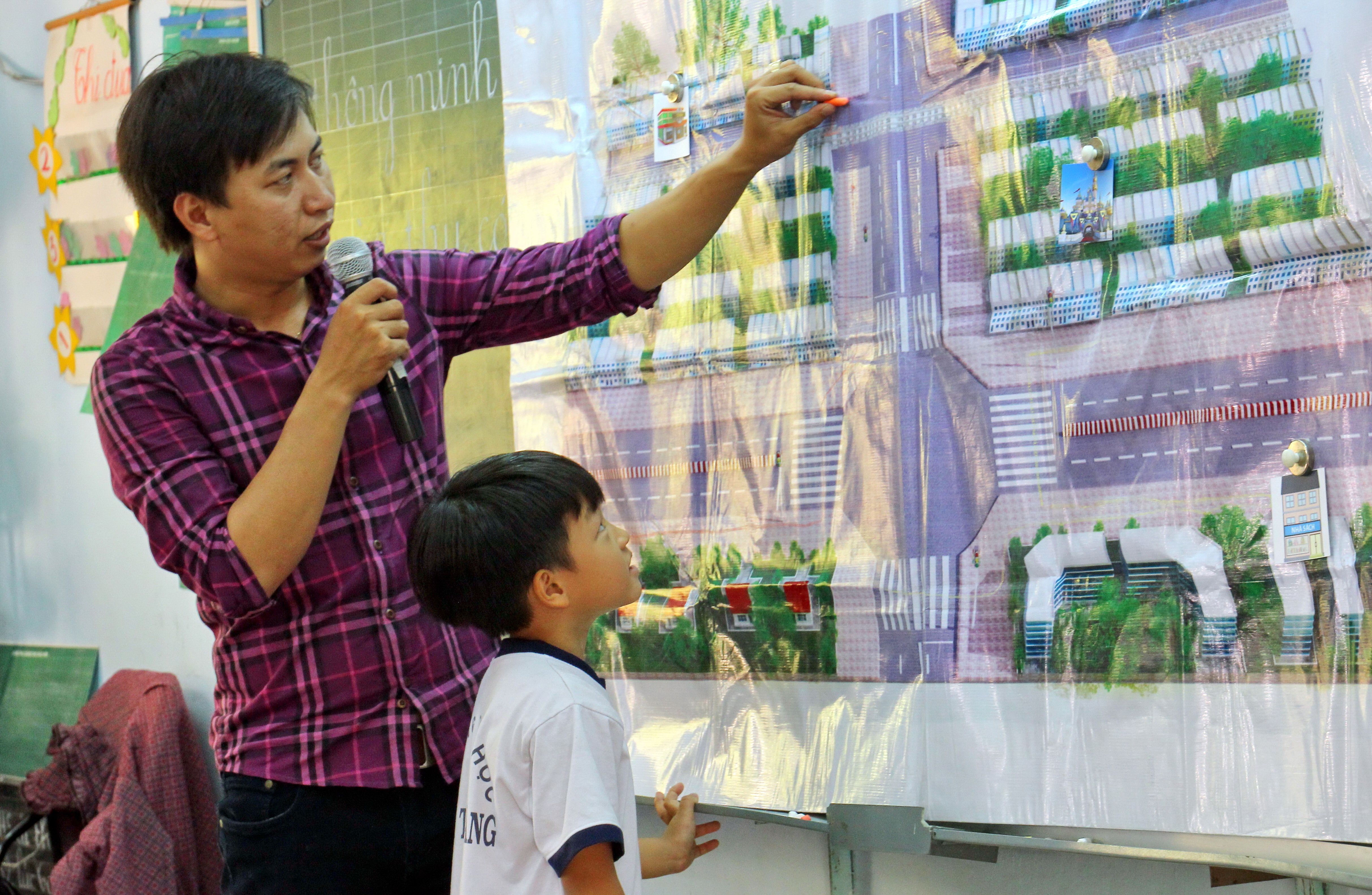 A teacher guides a young student through a traffic simulation and imparts crucial messages of pedestrian safety.