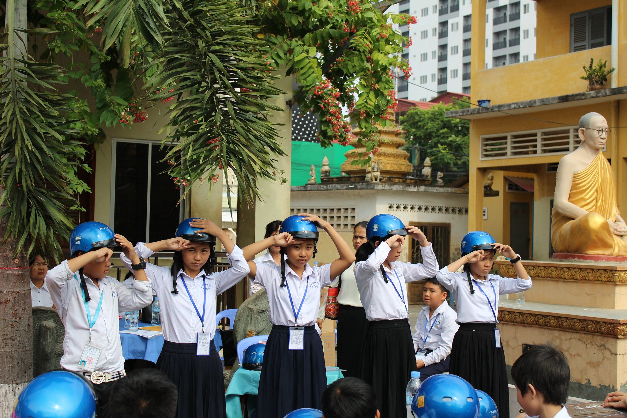 Students from Wat Toul Tompong Primary School use the two finger rule to measure the correct positioning of their helmets.