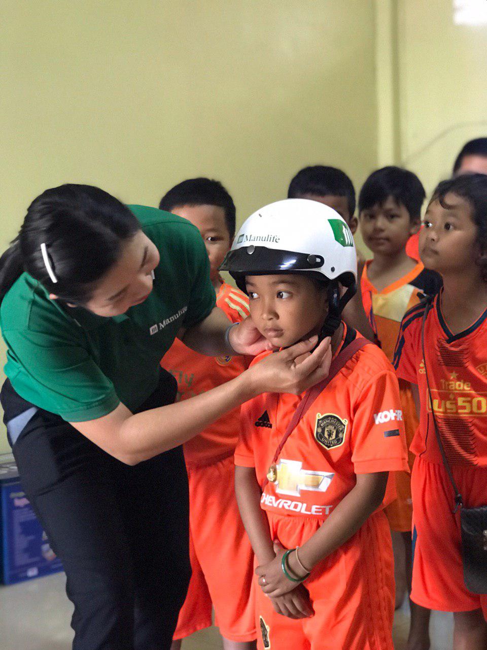 Manulife Cambodia volunteers support AIP Foundation in conducting helmet measurements for students through Helmets for Families 