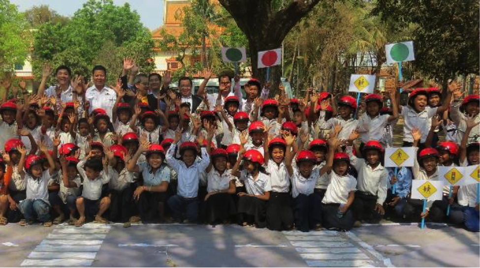 Students and representatives of AAC and AIP Foundation celebrate the end of a successful day of traffic simulations, road safety lessons, and helmet-donating.