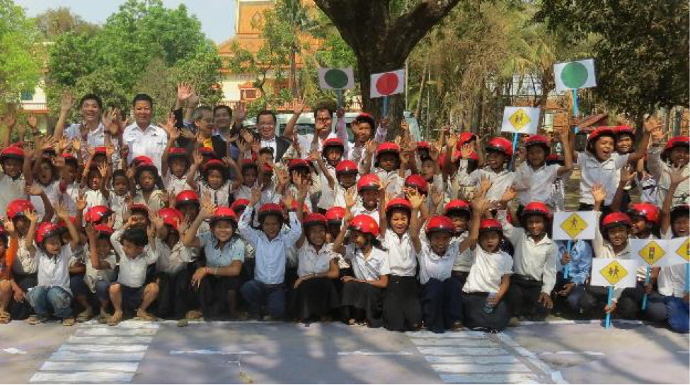 Students and representatives of AAC and AIP Foundation celebrate the end of a successful day of traffic simulations, road safety lessons, and helmet-donating.