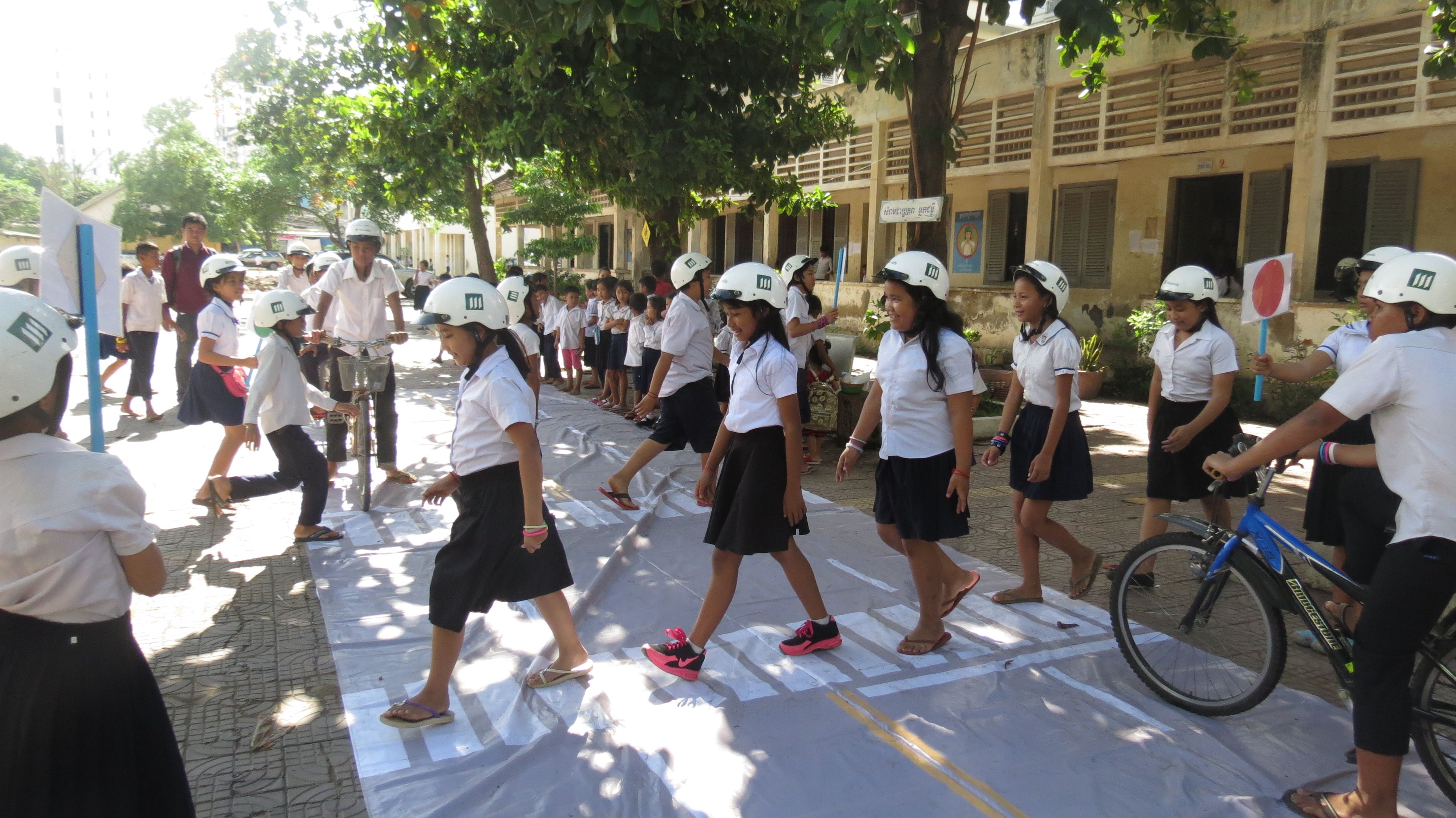 Children at Sothearos Primary School participate in a road simulation as part of the Helmets for Families program.