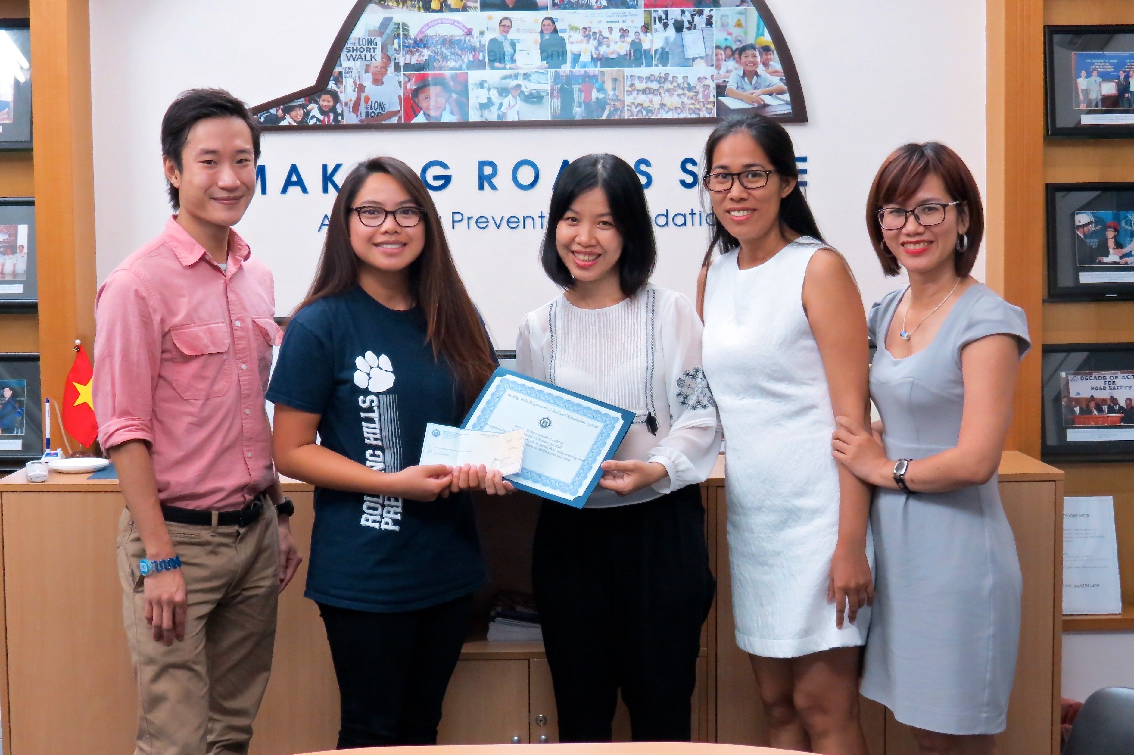 Amy Lee, a senior at Rolling Hills Prep and Renaissance Schools in California, presents the proceeds from a recent fundraiser her school hosted to William Bach Tran, Truong Thi Nguyet Trang, Bui Thi Dem Hong, and Nguyen Thi Huong Giang, all members of AIP Foundation’s programs staff.