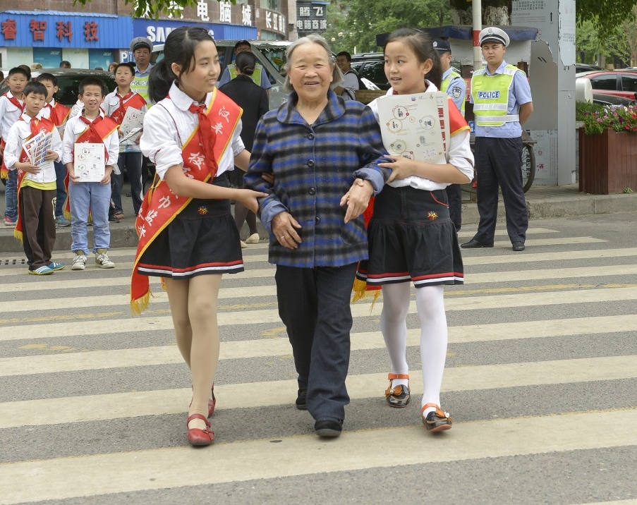 Students help their community cross the street safely