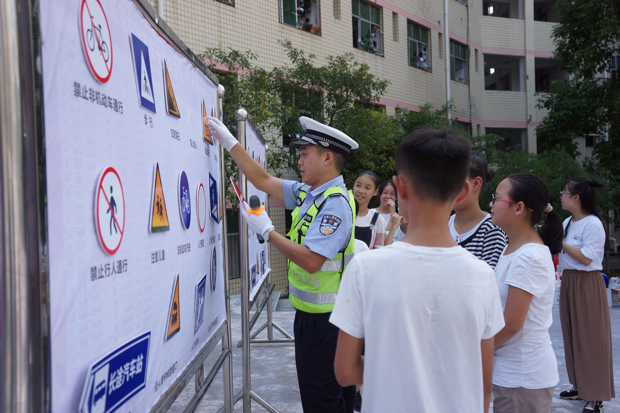 A local police officer and students engage in an interactive lesson on traffic signals.