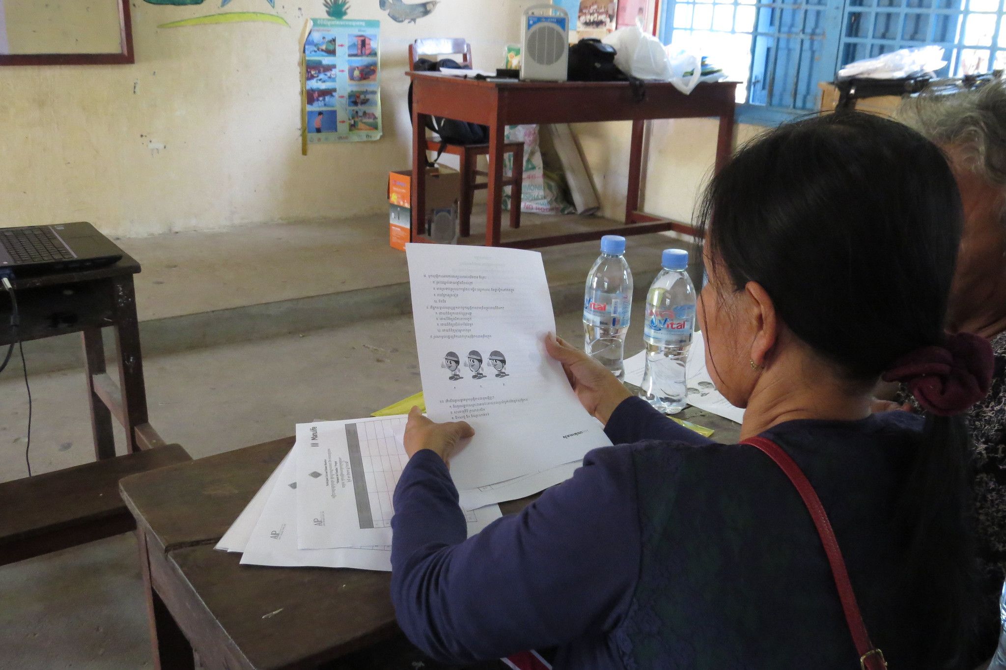Parents study how to correctly put on their motorcycle helmets.
