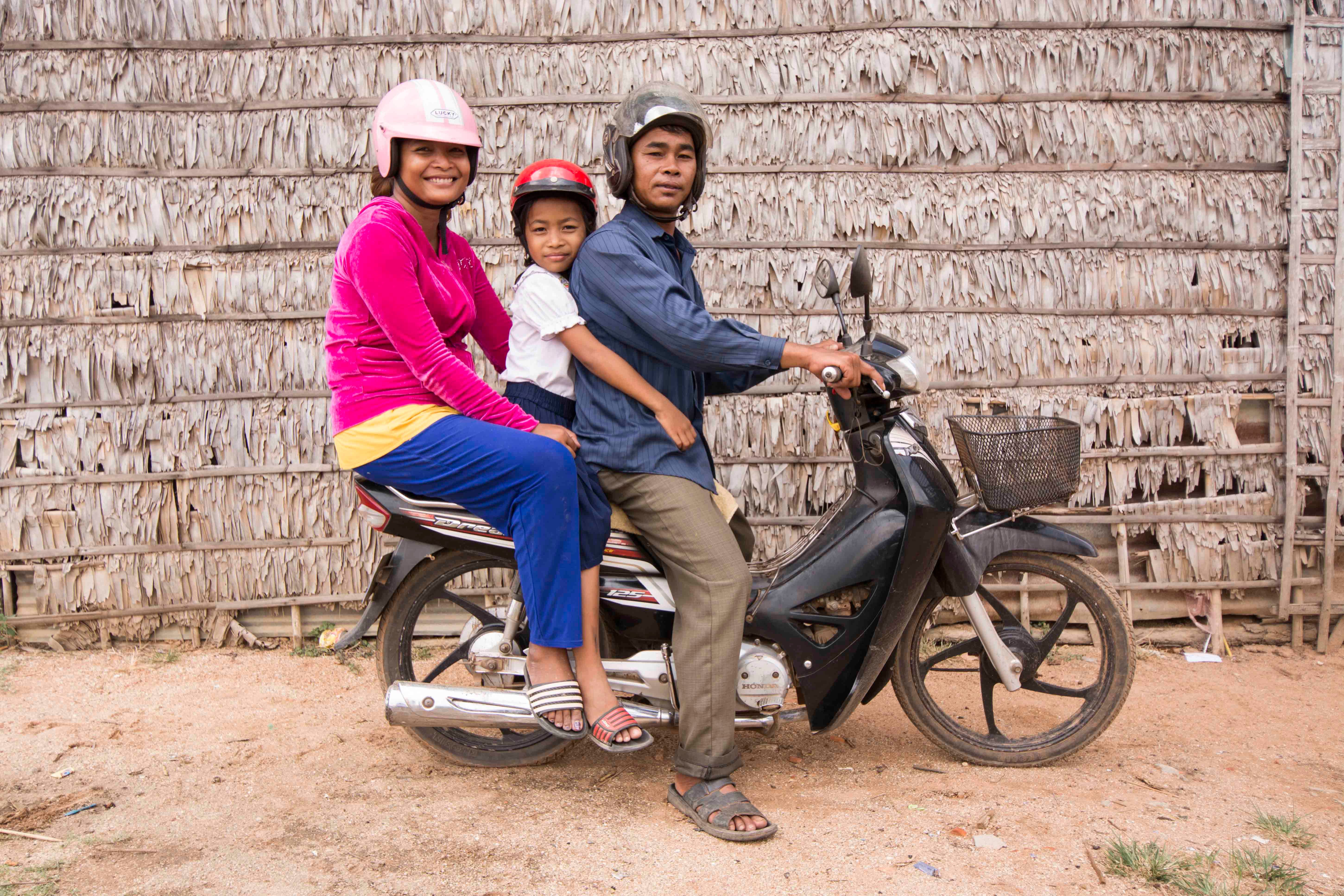 Chantheavin (center) received a helmet, which protected her from suffering a potential brain injury during a recent road crash, through the Head Safe. Helmet On. program.