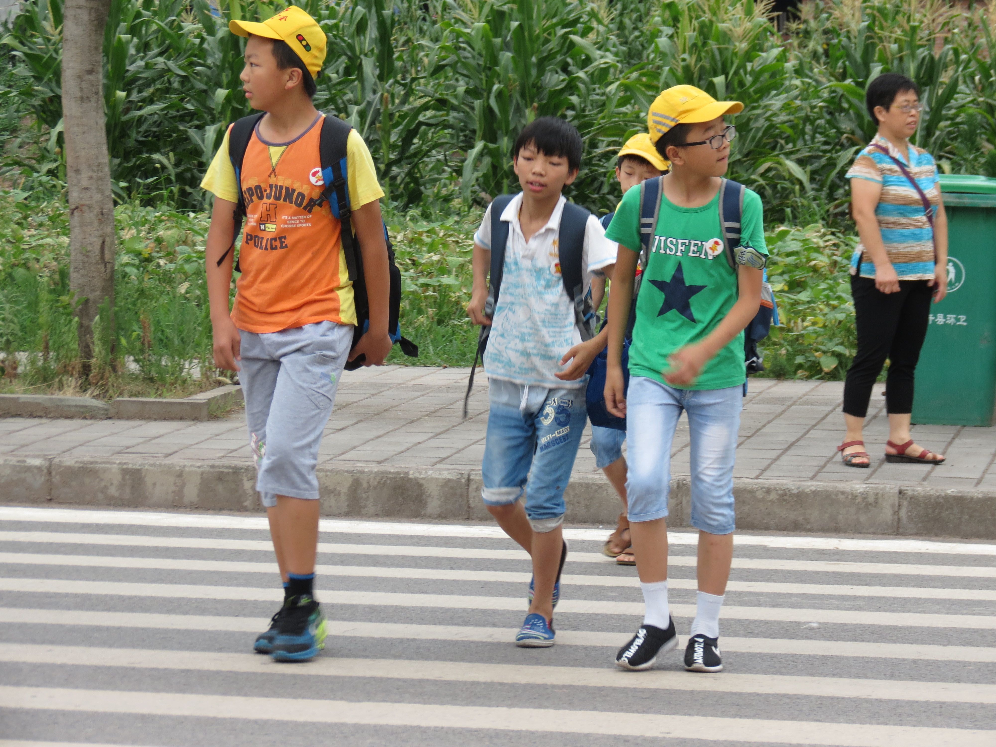 Students practice the safety rules (stop, look, listen, and cross) when crossing the road.