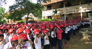 Students wear their new helmets at a handover ceremony