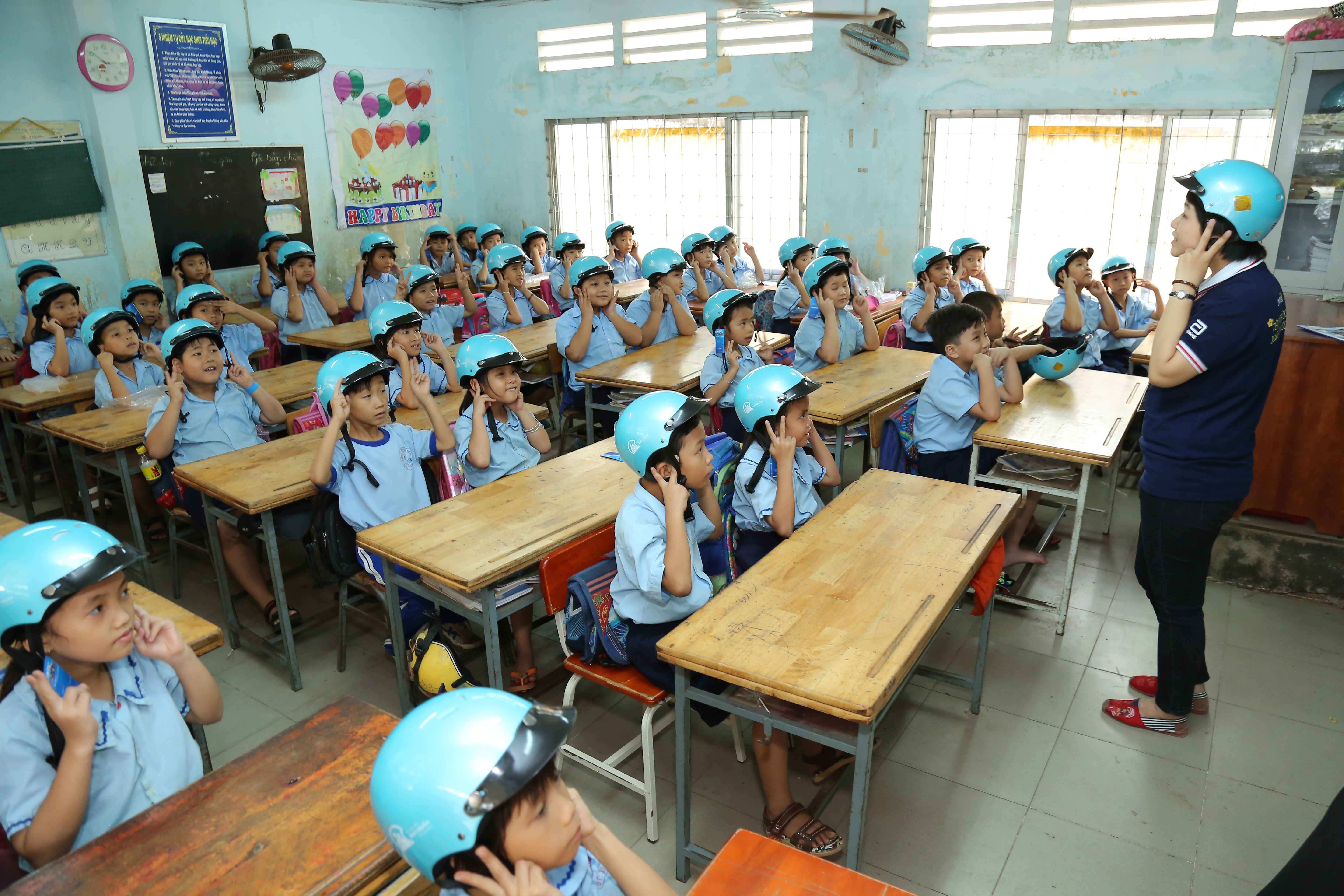 Students practice proper helmet wearing techniques during the kick-off event in Ho Chi Minh City’s Hoc Mon District.
