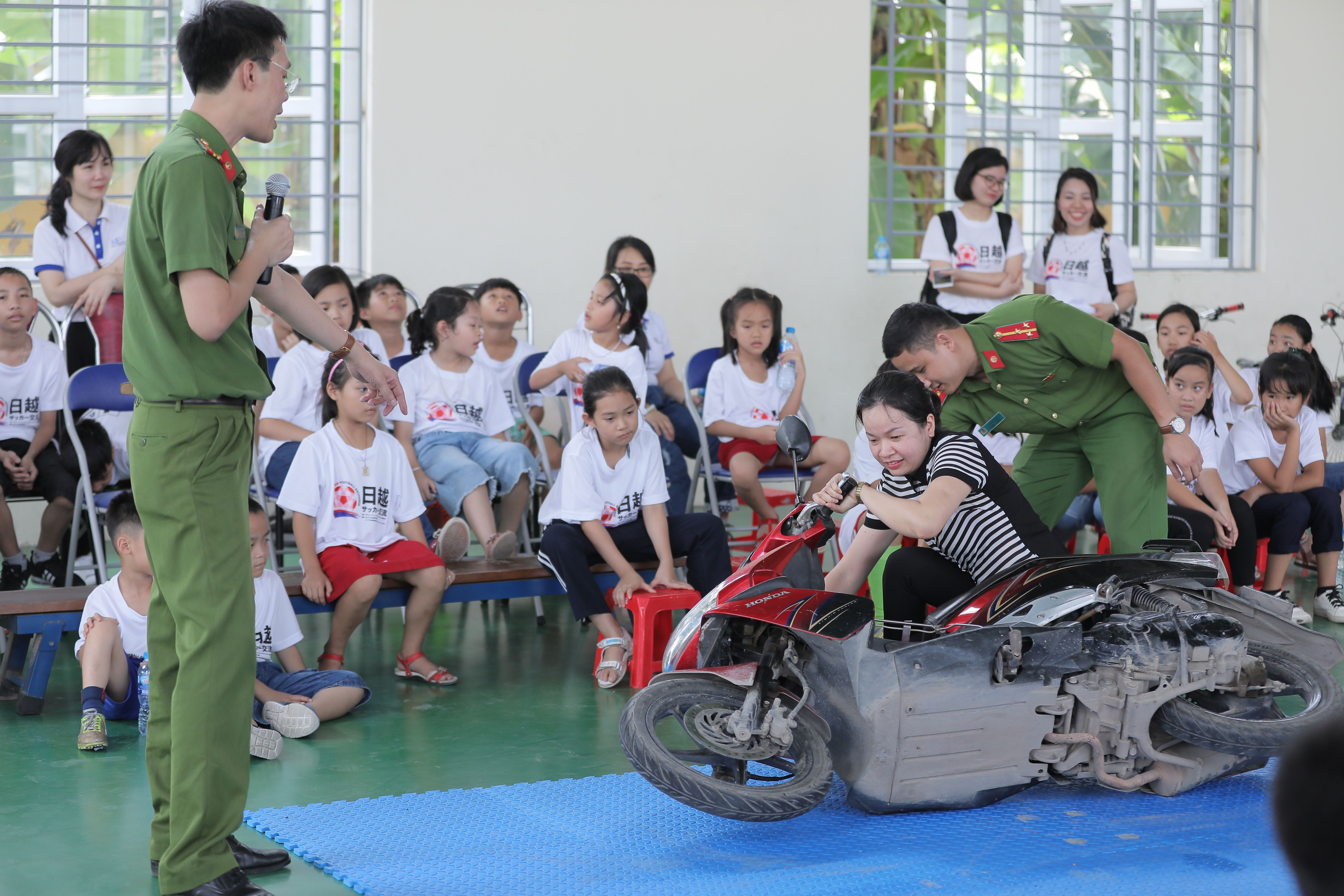 Police and parents demonstrate motorcycle safety to students.