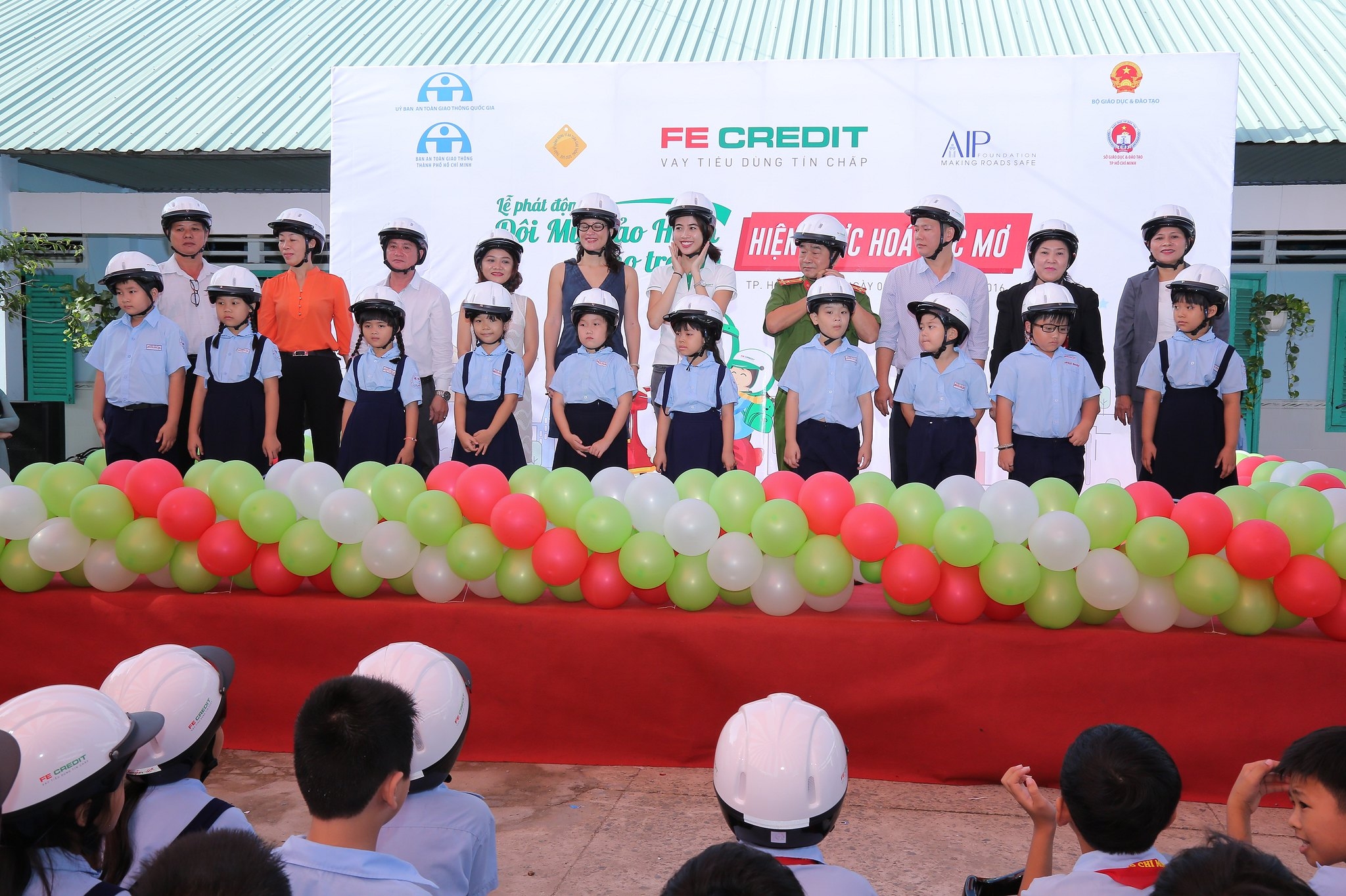 Distinguished guests participate in a helmet handover ceremony with students at Nguyen Van The Primary School.