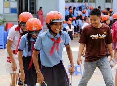 A UPS Volunteer participates in a Helmets for Kids game at a school in Vietnam.