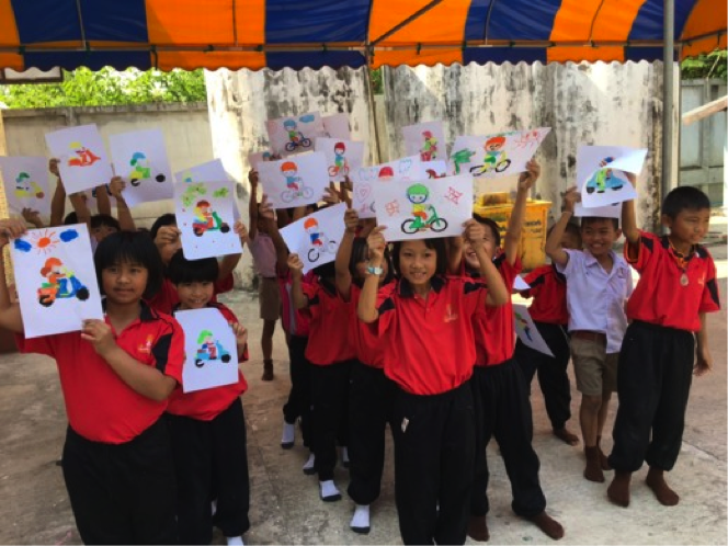Students proudly display their artwork after completing road safety activities.