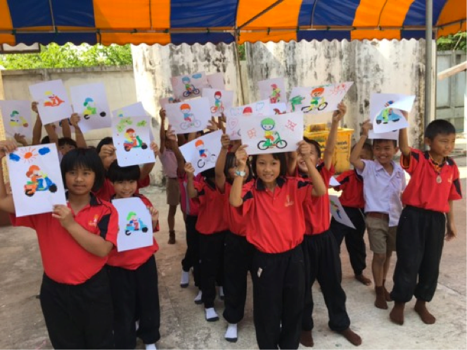Students proudly display their artwork after completing road safety activities.